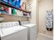 Functional laundry room with appliances, storage shelves, and tiled floor at 484 Harbor Winds Ct, Winter Springs, FL 32708