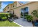 Back patio with sliding glass doors to the home and a concrete pad, with lush greenery around the perimeter of the patio at 484 Harbor Winds Ct, Winter Springs, FL 32708