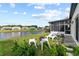 Backyard overlooking a beautiful lake with outdoor seating area, lush grass, and mature plantings at 5112 Jetsail Dr, Orlando, FL 32812