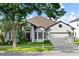 Charming single-story home featuring a well-manicured lawn, two-car garage, and beautiful tropical landscaping at 5112 Jetsail Dr, Orlando, FL 32812
