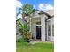 Stunning front entry showcasing meticulously maintained tropical landscaping and a stylish black front door at 5112 Jetsail Dr, Orlando, FL 32812
