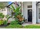 Close-up of the front entrance with meticulously maintained landscaping and black door adding a touch of elegance at 5112 Jetsail Dr, Orlando, FL 32812