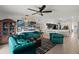 Open-concept living room with tufted emerald sofas, modern decor, and a view into the kitchen at 5112 Jetsail Dr, Orlando, FL 32812