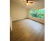 Bright bedroom featuring wood-look flooring and a large window with natural light at 5999 Lake Pointe Dr # 602, Orlando, FL 32822