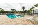 Community pool with sun loungers surrounded by palm trees in a tropical setting at 5999 Lake Pointe Dr # 602, Orlando, FL 32822