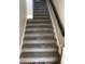 Carpeted staircase with modern railing leading to the upper level of the home at 5999 Lake Pointe Dr # 602, Orlando, FL 32822