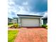 Charming one-story home featuring a brick driveway, a two-car garage, and manicured landscaping at 6028 Bimini Ave, Haines City, FL 33844