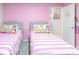 Charming bedroom featuring two twin beds with pink bedding and princess-themed decor at 7352 Oakmoss Loop, Davenport, FL 33837