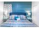 Comfortable bedroom featuring a large bed with blue accents, bedside tables, lamps, and a decorative headboard at 7352 Oakmoss Loop, Davenport, FL 33837