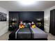 Stylish bedroom with a plush bed, dark accent wall, and playful Mickey and Minnie Mouse decor at 7352 Oakmoss Loop, Davenport, FL 33837