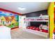 Bright bedroom featuring a bunk bed with Mickey Mouse-themed bedding and colorful cartoon-themed walls at 7352 Oakmoss Loop, Davenport, FL 33837