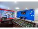 Spacious game room featuring a foosball table, pool table, comfortable couch, and colorful Marvel-themed decor at 7352 Oakmoss Loop, Davenport, FL 33837