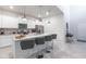 Bright, modern kitchen with granite countertops, stainless steel appliances, and a spacious island with bar stools at 7352 Oakmoss Loop, Davenport, FL 33837