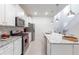 Well-equipped kitchen with stainless steel appliances, white cabinetry, granite counters, and tile backsplash at 7352 Oakmoss Loop, Davenport, FL 33837