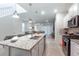 Open-concept kitchen with a large island, stainless appliances, and a seamless transition to the dining and living areas at 7352 Oakmoss Loop, Davenport, FL 33837