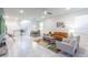 Bright living room with neutral tones, comfortable furniture, and an open layout connecting to the dining area and kitchen at 7352 Oakmoss Loop, Davenport, FL 33837
