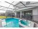 Inviting outdoor pool and hot tub with screened enclosure and patio area, perfect for relaxation and entertainment at 7352 Oakmoss Loop, Davenport, FL 33837