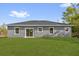View of the backyard featuring a newly installed lawn and sliding glass door to the home's interior at 75 Guava Ter, Ocklawaha, FL 32179