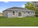 A view of the backyard featuring a newly installed lawn and a sliding glass door to the home's interior at 75 Guava Ter, Ocklawaha, FL 32179