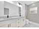 Modern bathroom with double vanity sinks, granite countertops, framed mirrors, and walk-in shower with gray tile at 75 Guava Ter, Ocklawaha, FL 32179