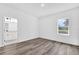 A primary bedroom with wood-look flooring, a view to the backyard, and an en suite bathroom at 75 Guava Ter, Ocklawaha, FL 32179