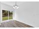 Dining area that looks out to the green backyard with a modern chandelier and luxury vinyl plank flooring at 75 Guava Ter, Ocklawaha, FL 32179
