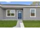 Up close view of the front door, which is blue with glass inserts. White trim borders the windows and door at 75 Guava Ter, Ocklawaha, FL 32179