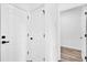 Hallway featuring white doors, with black hardware, and wood-look floors at 75 Guava Ter, Ocklawaha, FL 32179