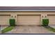 A well-maintained three car garage framed with manicured landscaping and a concrete driveway at 7660 Ripplepointe Way, Windermere, FL 34786