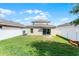 Spacious backyard with well-maintained lawn, privacy fence and a sliding glass door to the home at 812 Marcel Loop, Davenport, FL 33837