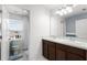 Bright bathroom boasts double sinks with dark wood cabinetry and tile flooring at 812 Marcel Loop, Davenport, FL 33837