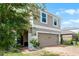 Two-story home with brick driveway, attached garage and mature landscaping at 812 Marcel Loop, Davenport, FL 33837
