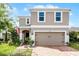 Two-story home with brick driveway, attached garage and manicured landscaping at 812 Marcel Loop, Davenport, FL 33837