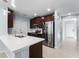 Modern kitchen with stainless steel appliances, white countertops, and dark wood cabinets at 812 Marcel Loop, Davenport, FL 33837