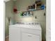 Functional laundry area equipped with a washer, dryer, and storage shelves at 8205 Sw 78Th Terrace Rd, Ocala, FL 34476