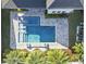 Aerial view of a backyard oasis featuring a pool, spa, and travertine decking surrounded by manicured landscaping at 8638 Finsen St, Orlando, FL 32827