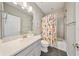 This stylish bathroom features a shower with tub and decorative curtain with gray tiled floor at 8638 Finsen St, Orlando, FL 32827