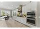 Modern kitchen featuring white cabinets, stainless steel appliances, tile backsplash and adjacent breakfast nook at 8638 Finsen St, Orlando, FL 32827