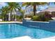 Inviting pool featuring a waterfall, palm trees, and lush landscaping, perfect for relaxation and entertainment at 8638 Finsen St, Orlando, FL 32827