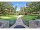 Well-maintained community path leading to a beautiful lake surrounded by lush greenery and mature trees at 102 Fairway Dr # 102, Longwood, FL 32779