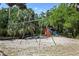 Community playground with multiple swings and play equipment surrounded by lush greenery at 102 Fairway Dr # 102, Longwood, FL 32779