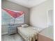 Bedroom with a single bed, a light blue nightstand, and a red scarf decoration over the window at 106 Alhambra Ave, Altamonte Springs, FL 32714
