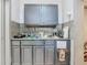 Compact kitchen featuring gray cabinetry, tile backsplash and granite countertops at 106 Alhambra Ave, Altamonte Springs, FL 32714