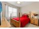 Bedroom featuring natural wood furniture, bright red comforter, and tile flooring at 1199 Playa Del Sol Ln, St Cloud, FL 34771