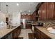 Spacious kitchen featuring dark wood cabinets, granite countertops, and stainless steel appliances at 1199 Playa Del Sol Ln, St Cloud, FL 34771