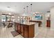 Open-concept kitchen island with granite countertops, pendant lighting, and stainless steel appliances at 1199 Playa Del Sol Ln, St Cloud, FL 34771