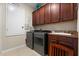 Functional laundry room includes washer, dryer, storage cabinets, and tile flooring at 1199 Playa Del Sol Ln, St Cloud, FL 34771