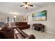 Spacious living room with tile floors, leather seating, and a large mounted TV at 1199 Playa Del Sol Ln, St Cloud, FL 34771