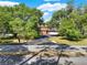 Charming home with mature trees lining the driveway, creating a private and inviting entrance at 12030 Kirby Smith Rd, Orlando, FL 32832