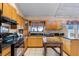 Well-equipped kitchen featuring granite countertops, wood cabinets, and black appliances at 12030 Kirby Smith Rd, Orlando, FL 32832